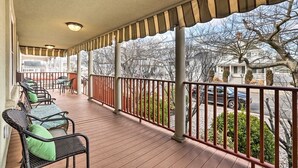 A covered porch with outdoor furniture, a railing, and a view of the street and buildings. - Beautiful Spacious Beach Home, Private Deck & Grill, 5-min to Beach w/ Badges (Point Pleasant Beach)