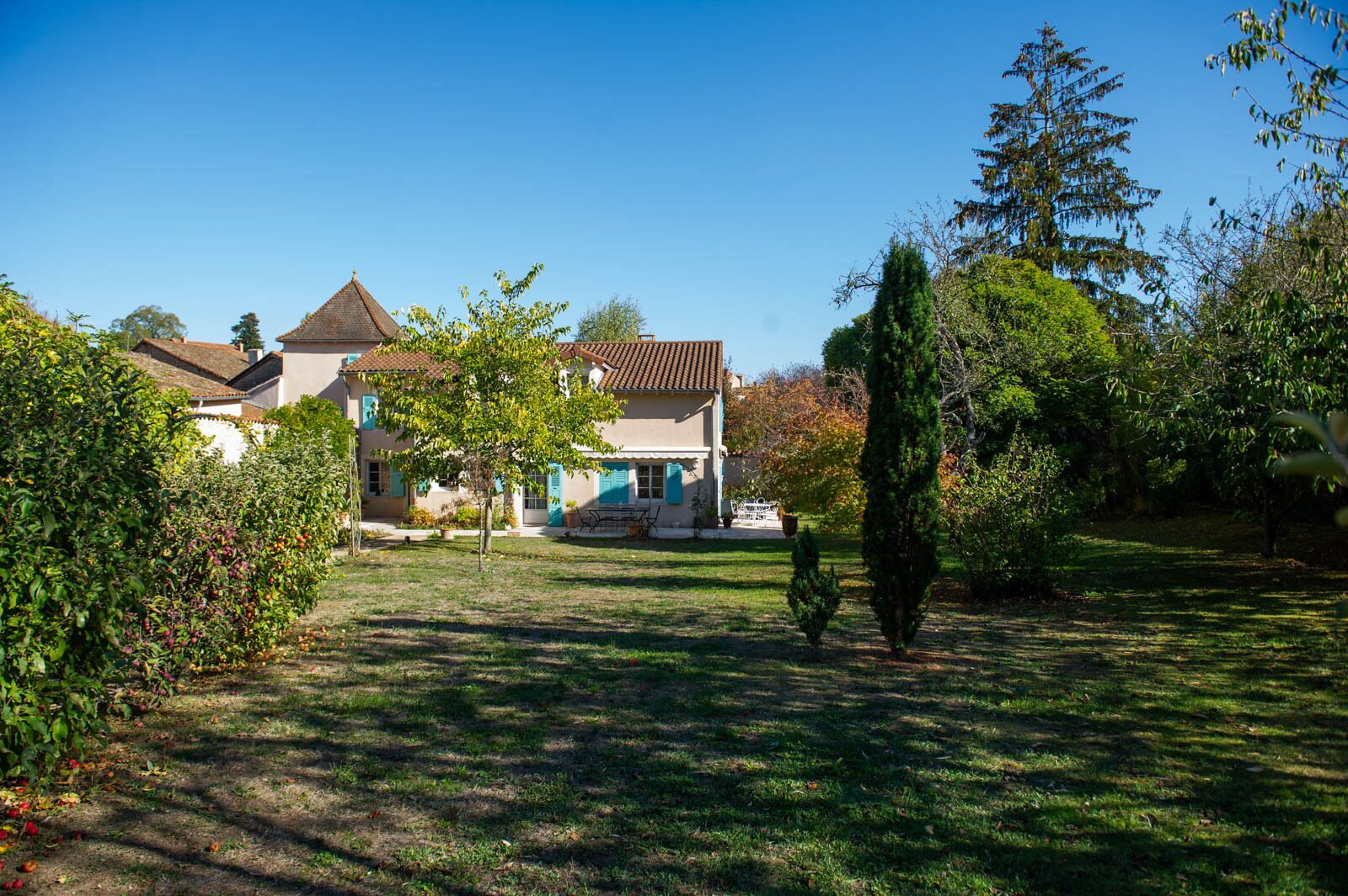 A house with a tiled roof, a small garden, and a lawn.