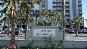 A multi-story building named 'Tidewater Condominium' with a sign in front. - Newly Remodeled, Beachfront Condo, Sleeps Six, Resort Amenities! (Orange Beach)