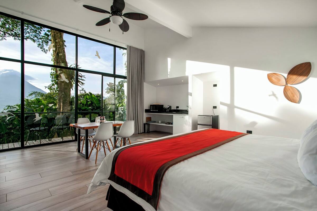 Ein modernes Hotelzimmer mit einem großen Bett, einem Schreibtisch und einem Essbereich.