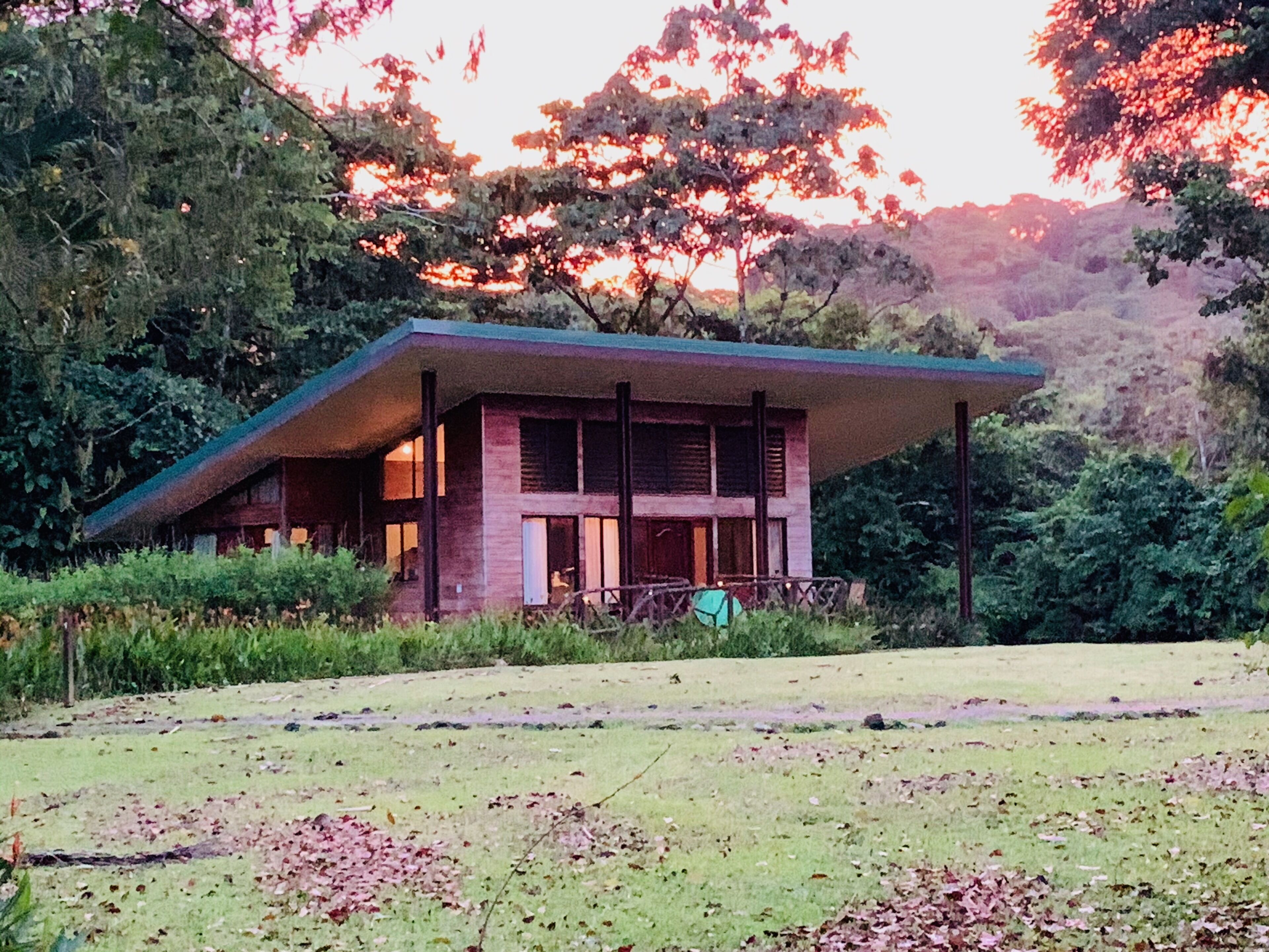 A modern house with a sloped roof, large windows, and a porch.