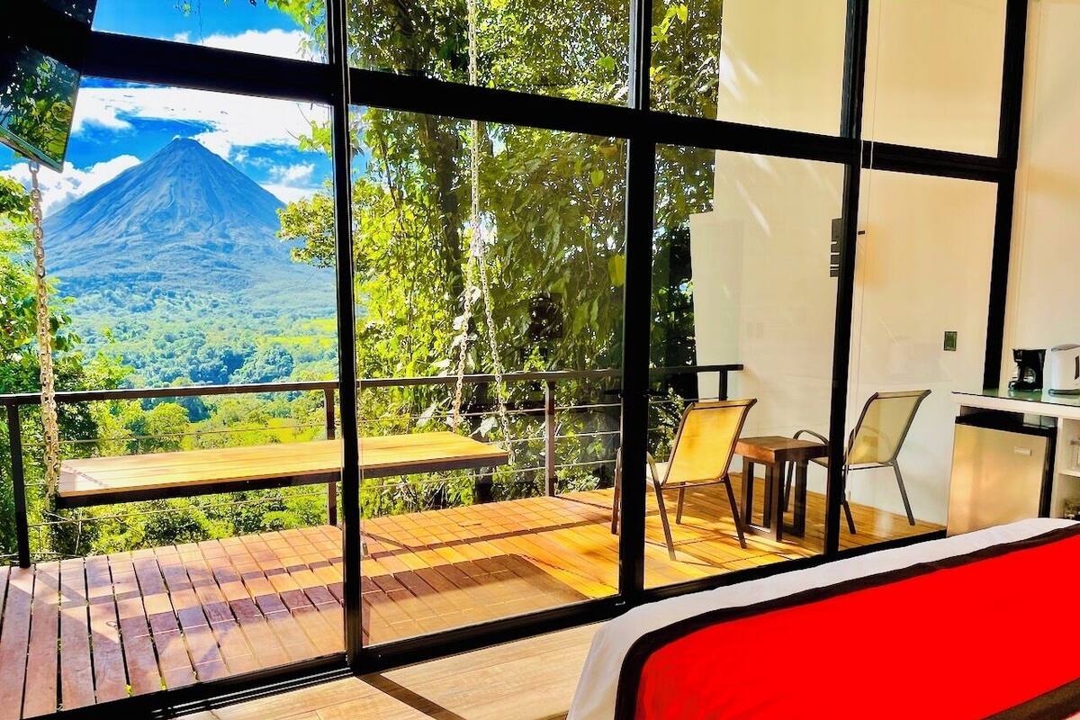 Ein Zimmer mit großem Fenster und Blick auf eine Berglandschaft.