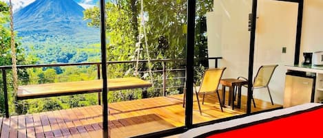 A room with a large window overlooking a mountainous landscape.