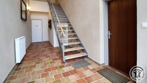 A staircase leading to an upper floor, a white door, and a wooden door. - Gîte St Michel - SAINT-CLEMENT-LES-PLACES (SAINT-CLEMENT-LES-PLACES)