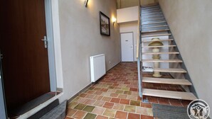A staircase with a handrail, a door, and a radiator on the wall.