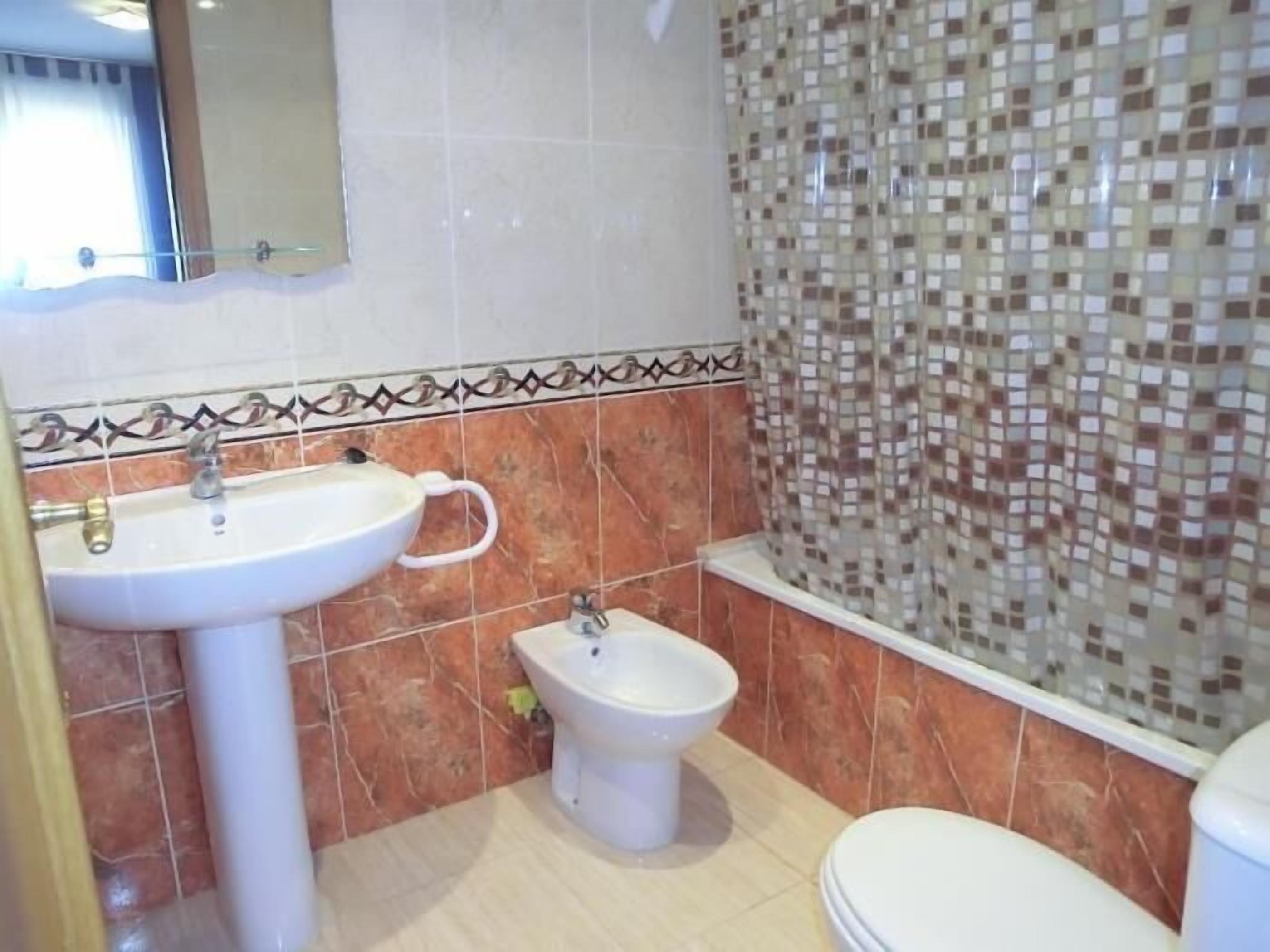 Un baño con lavamanos, bidé e inodoro.