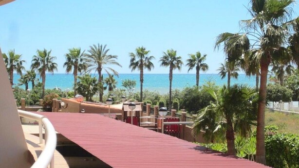 A red pathway leading to a beach with palm trees and a clear blue sky. - AP Costas - Marina Mar Marina D'or / Two Bedrooms (Oropesa)