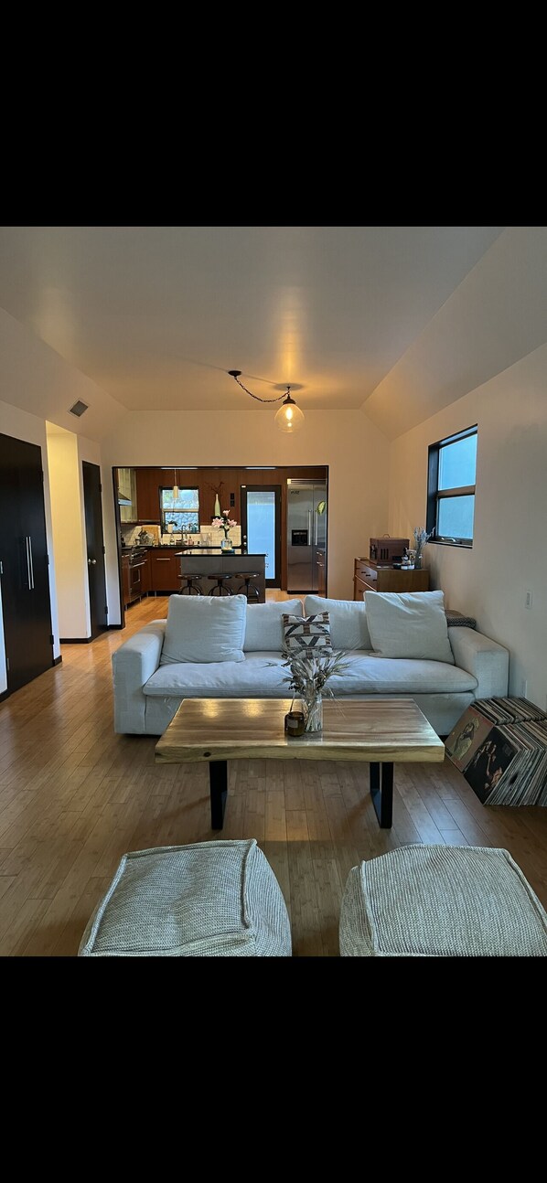 Relax in this stylish living area with a sofa set and kitchenette, offering a view of the outdoors.