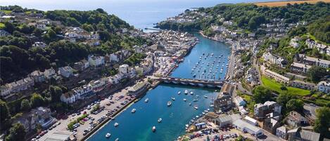A coastal town with a marina, houses, and a road leading to the water.