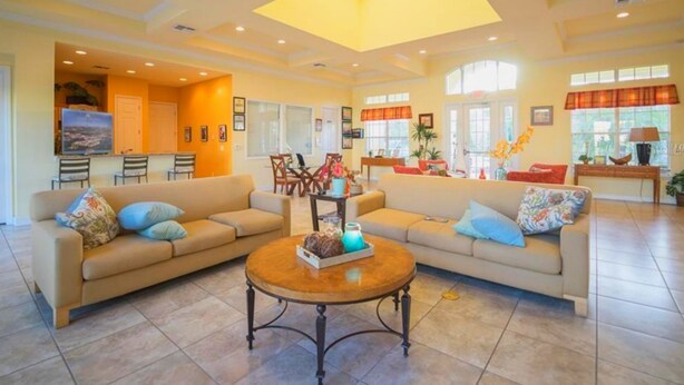 A spacious living area with two sofas, a coffee table, and a dining area with chairs.