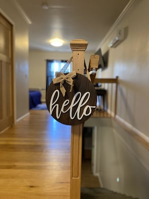 A wooden sign with the word "hello" in white cursive letters, tied with a burlap bow, hanging on a wooden post in a hallway. - Devils Lake, hiking & Dells near peaceful retreat (Merrimac)