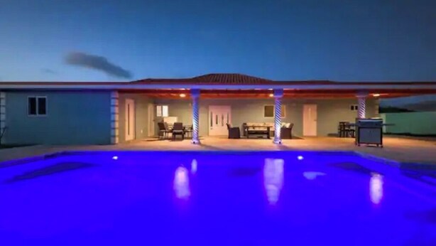 Ein Haus mit Schwimmbecken im Abenddämmerung.