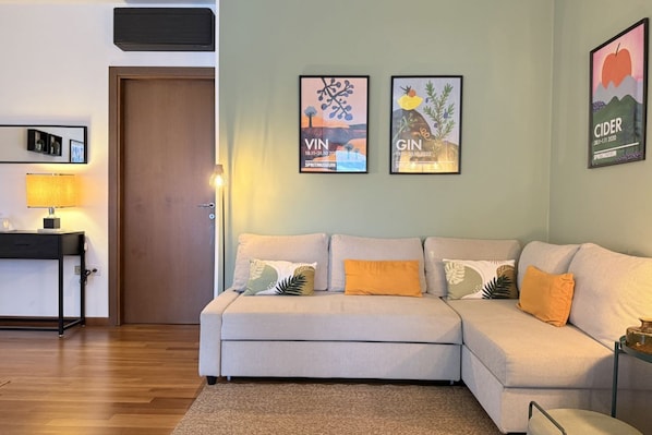 A living room with a sofa, a lamp, and framed artwork on the wall. - S255 - Sirolo, new three-room apartment a stone's throw from the center (Sirolo)