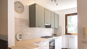 A modern kitchen with white cabinets, a gas stove, and a window with a view. - S255 - Sirolo, new three-room apartment a stone's throw from the center (Sirolo)