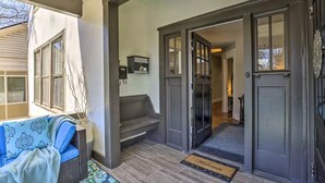 A foyer with a dark wooden door, a blue patterned sofa, and a small staircase leading to an upper level. - Paradise at Piedmont Park & Near Atlanta Attractions (Atlanta)