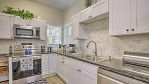 A modern kitchen with white cabinets, a built-in microwave, a stainless steel oven, a sink, and a toaster. - Paradise at Piedmont Park & Near Atlanta Attractions (Atlanta)