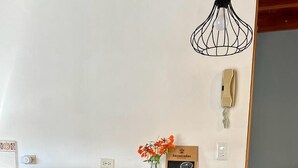 Ein Holzespeisetisch mit Stühlen, eine Blumenvase und ein 'Welcome'-Schild an der Wand.