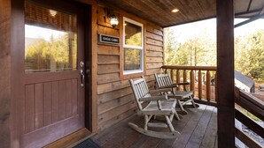 Eine Holzhütte mit Veranda, Schaukelstühlen und einem Schild mit der Aufschrift 'Eagle Cabin'.