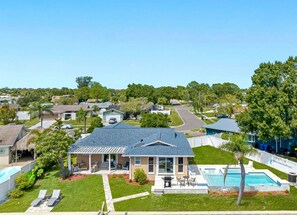 A residential property with a large house featuring a covered patio, a swimming pool, and a well-maintained lawn. - NEW Heated Salt Pool & Spa on Waterfront Canal (Tampa)