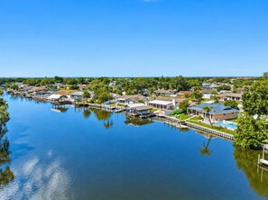 A residential area with houses along a waterway, docks, and a clear sky. - NEW Heated Salt Pool & Spa on Waterfront Canal (Tampa)