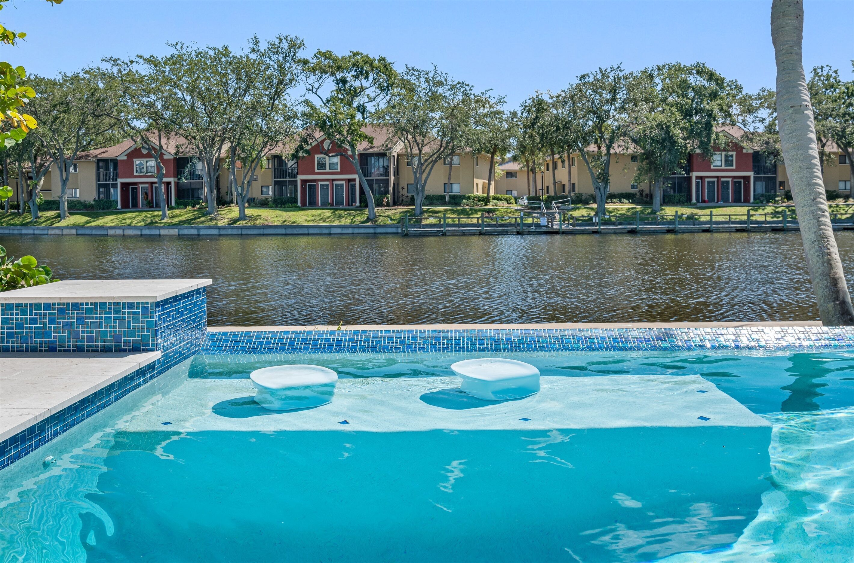 Una piscina con vistas claras a los edificios circundantes y una superficie acuática tranquila.