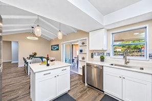 A modern kitchen with white cabinetry, a dishwasher, and pendant lighting. - Waterfront | Heated Salt Pool & Spa (Tampa)