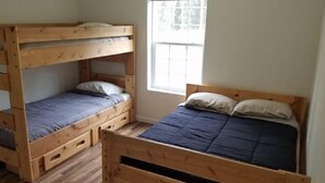 Ein Zimmer mit zwei Etagenbetten, einem Fenster mit Aussicht und Holzboden.
