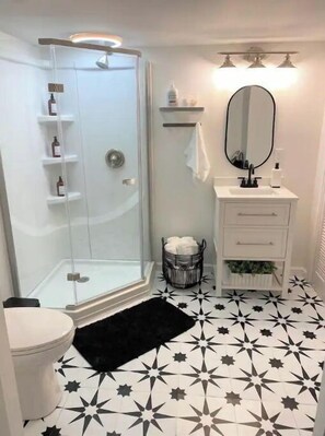 Bathroom features a shower enclosure, sink, and toilet, set against a star-patterned tile floor.