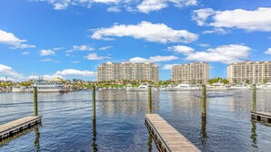 A waterfront hotel with multiple high-rise buildings, docked boats, and a clear blue sky.