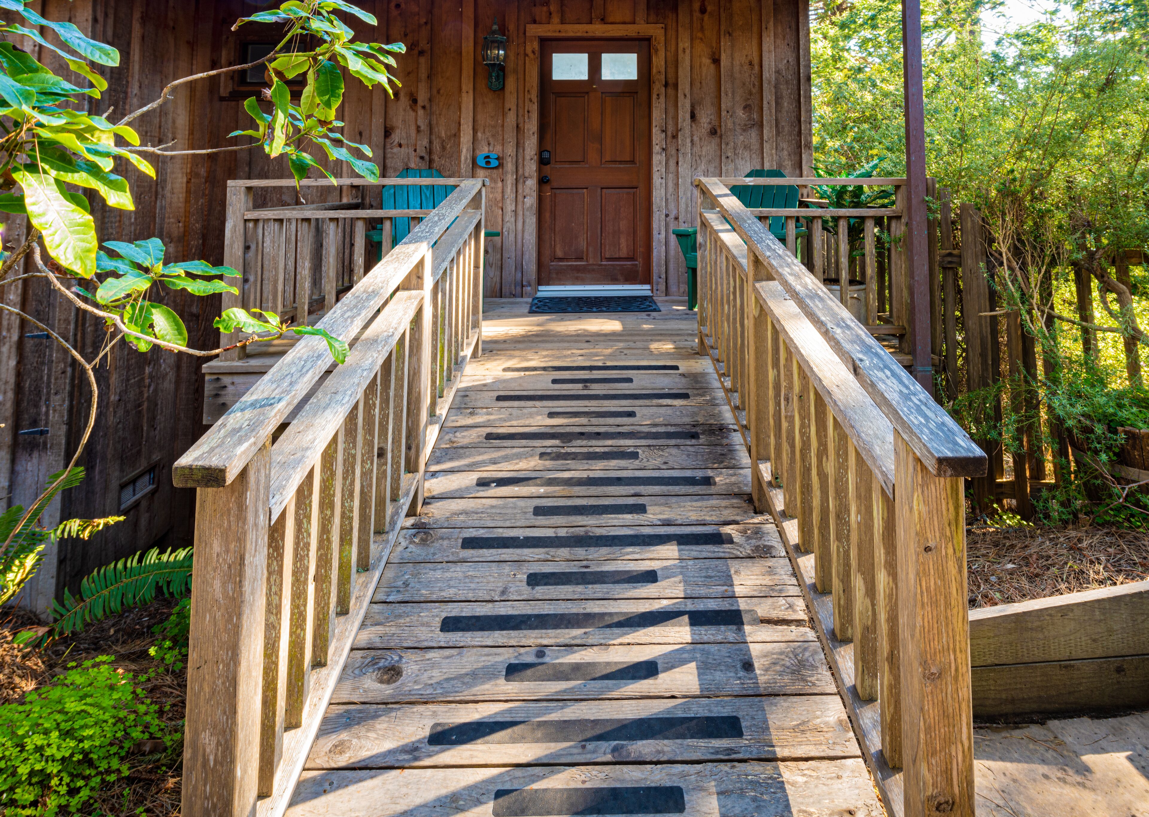 A wooden staircase leading to a cabin with a door and windows.