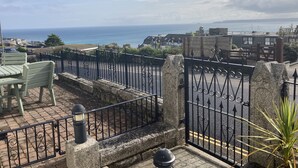 A terrace with a view of the sea, a stone wall, and a metal gate. - St James Rest - sleeps 4 guests  in 2 bedrooms (St Ives)