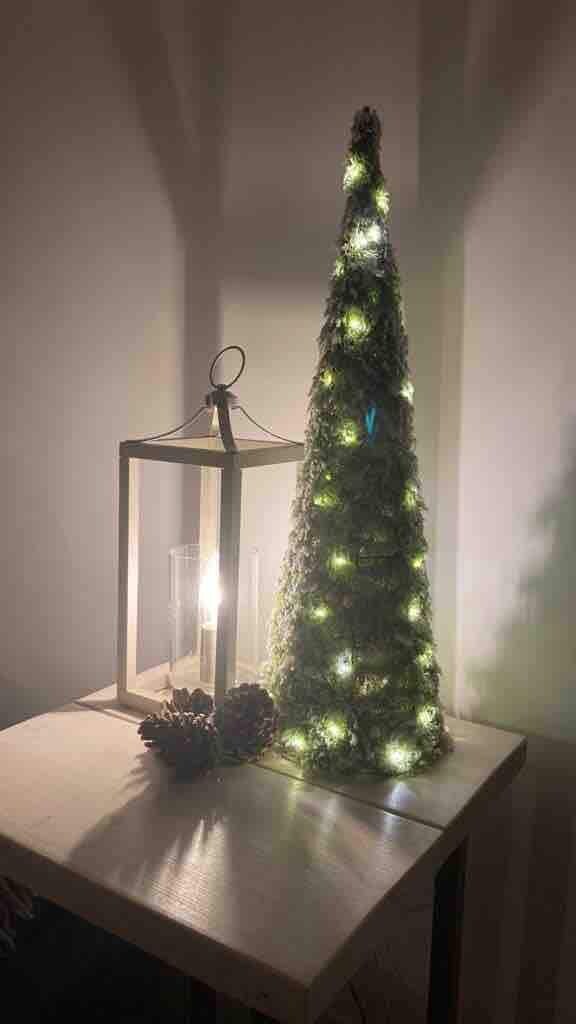 Un árbol de Navidad con luces sobre una mesa.