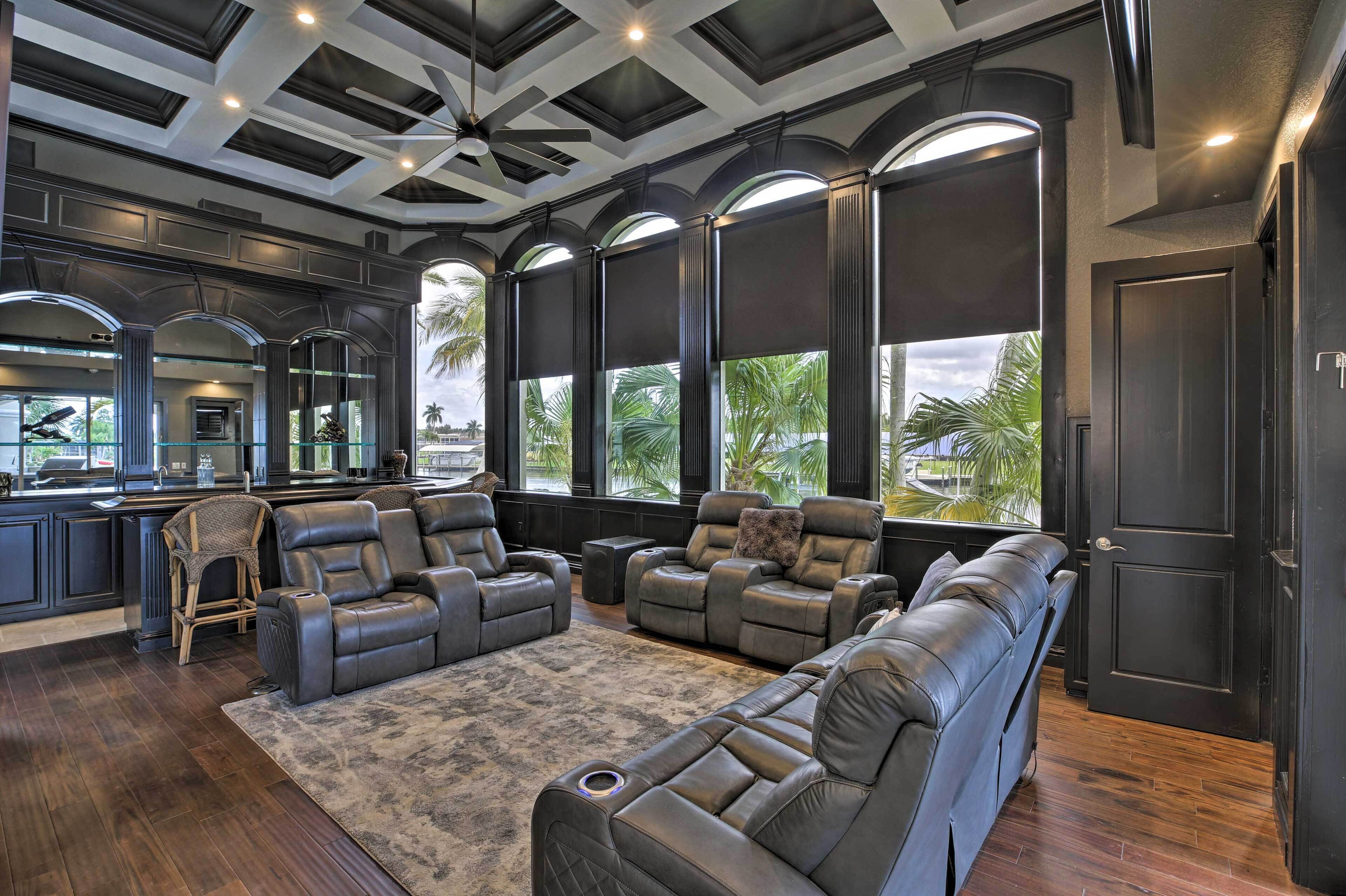 A modern living room with a large sectional sofa, a fireplace, and a view of palm trees.