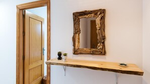 A wooden door, a rustic mirror, and a small wooden shelf with two potted plants. - Cosy Urban Penthouse In The Heart Of Fuengirola (FUENGIROLA)