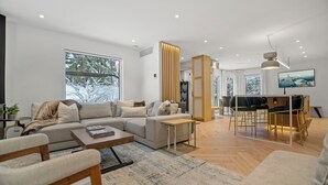 Una sala de estar moderna con un sofá, una mesa de centro y un comedor.