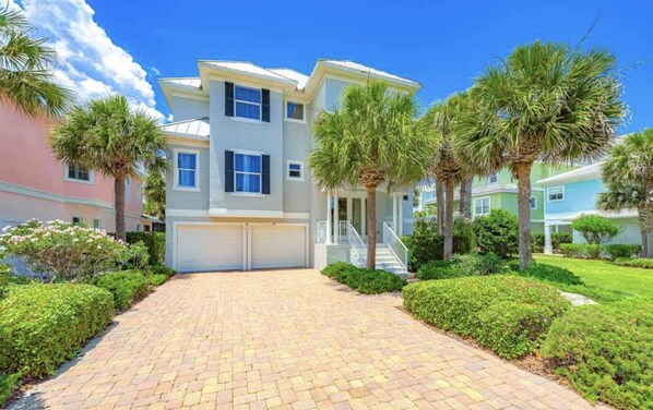 A two-story residential building with a paved driveway and palm trees. - Ocean Hammock Paradise-5BR 4BA, Private Pool, 1 Min walk to Beach,Family Retreat (Palm Coast)