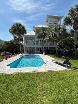 A two-story building with a swimming pool, surrounded by palm trees and a well-maintained lawn. - Ocean Hammock Paradise-5BR 4BA, Private Pool, 1 Min walk to Beach,Family Retreat (Palm Coast)