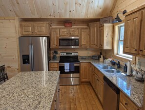 Enjoy cooking in this well-equipped kitchen with a refrigerator, microwave, oven, and dishwasher.