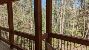 Eine Holzterrasse mit Blick auf einen Wald.