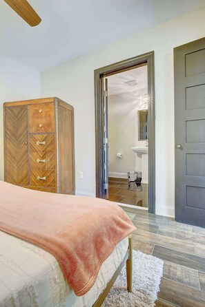 A bedroom with a bed, a wardrobe, and a bathroom visible through an open door.