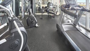 A gym with cardio equipment, weight machines, and a large window. - Hidden Treasure -3BR Sleeps 8 (Navarre Beach)
