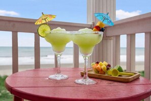 Deux cocktails sur une table, avec vue sur la plage.