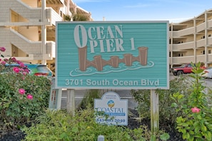 Un panneau indiquant l’emplacement d’Ocean Pier 1, avec son adresse et un numéro de téléphone à contacter pour les questions relatives à la gestion côtière.