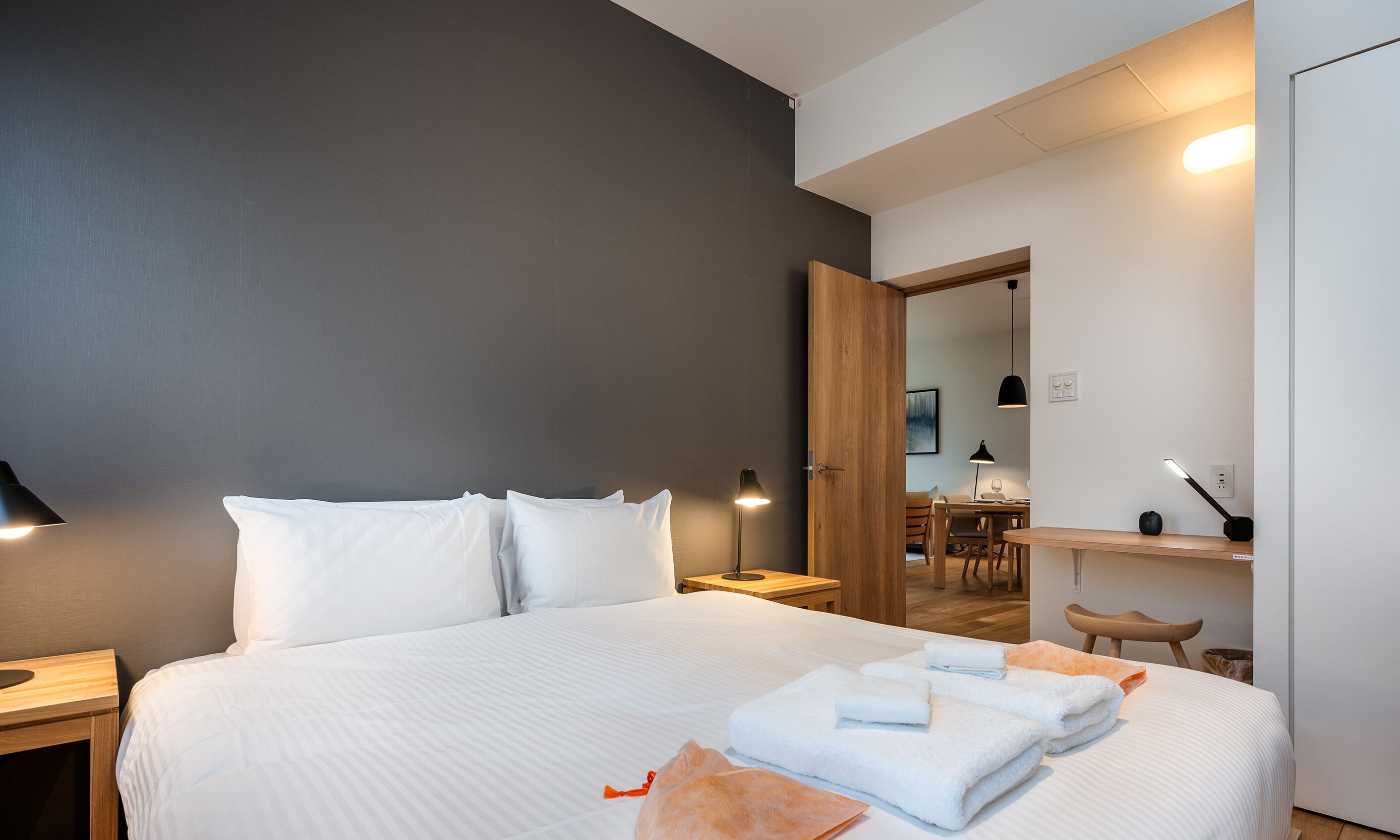 A hotel room with a large bed, a desk, and a chair.