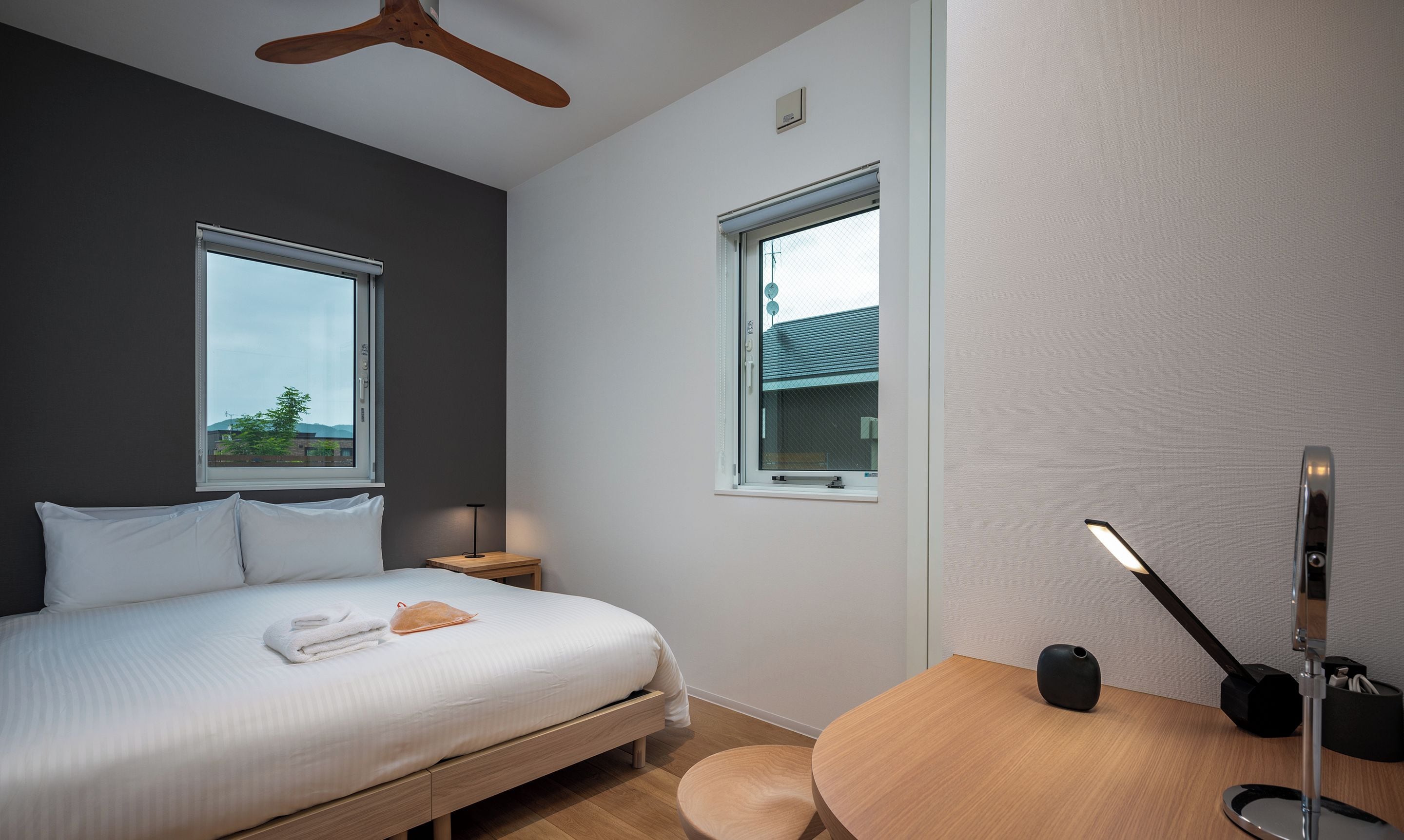 Une chambre à coucher moderne avec un lit, une table de chevet et un bureau avec une lampe.