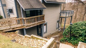 A two-story house with a wooden deck, a small porch, and a stone pathway leading to the front door. - Mountain Adventures with heated pool near Pittsburgh, State Parks, Falling Water (Champion)