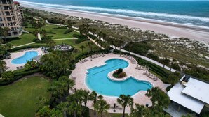 A resort with a large pool area, a beach view, and a well-maintained lawn. - Oceanfront | Turtle Dunes Luxury Penthouse | Intracoastal and Oceanfront Views | Double Balconies (Fernandina Beach)