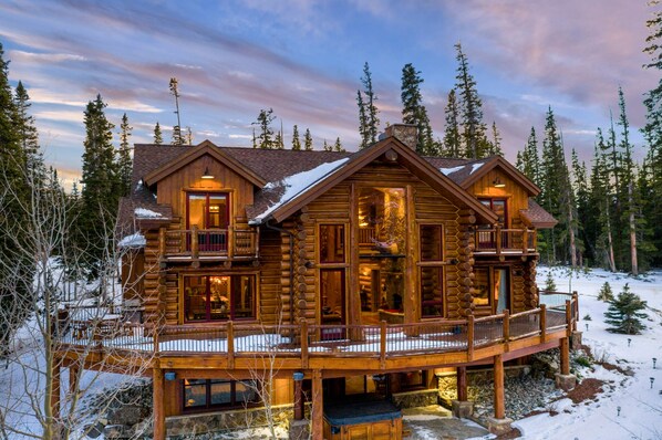 A log cabin with a balcony and a fireplace.