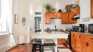 Uma cozinha moderna com armários de madeira, uma ilha branca e um espaço para café.