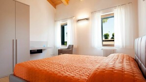 A modern bedroom with a large bed, a desk, and a chair. - Beautiful apartment for 6 guests with WIFI, TV and patio (Ca' Savio)